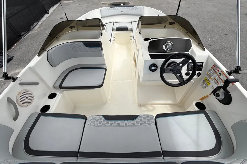 Slide: The Image of L'image montre le cockpit d'un Bayliner Element M17 de 2024 avec des sièges gris et blancs. - 17