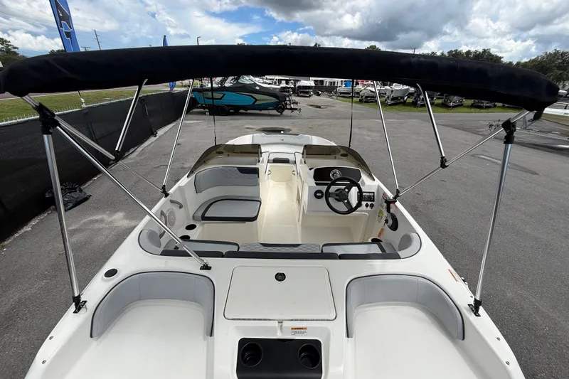 Slide: The Image of 2024 Bayliner Element M17 boat interior with seating and steering wheel under a canopy. - 15