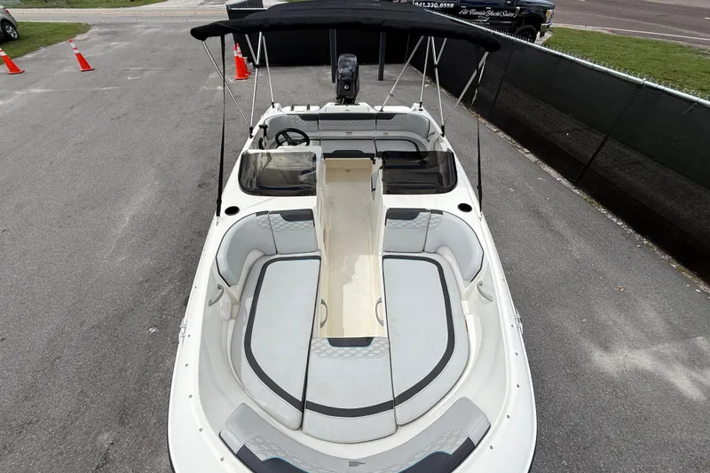 Slide: The Image of 2024 Bayliner Element M17 boat with spacious seating and canopy, parked on pavement. - 34