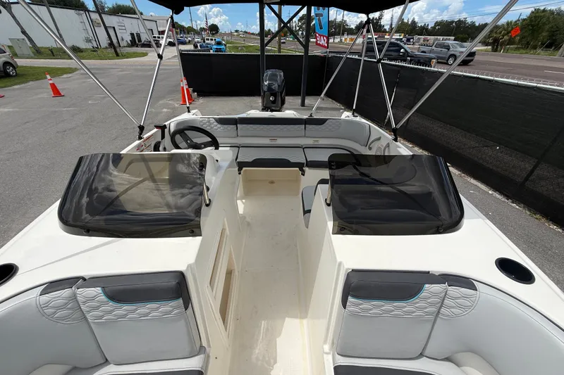 Slide: The Image of 2024 Bayliner Element M17 boat interior with seating and steering wheel, parked outdoors. - 37