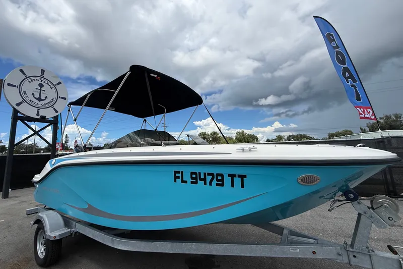 The Image of Bayliner Element M17 de 2024 sur une remorque, avec coque bleue et pare-soleil noir. - 0