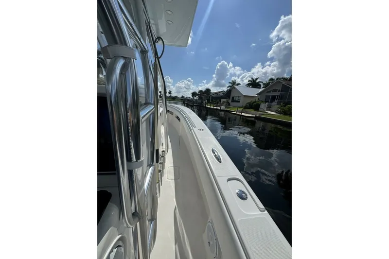 Slide: The Image of 2013 Invincible 36 Open Fisherman boat docked on a sunny day, reflecting on calm water. - 14