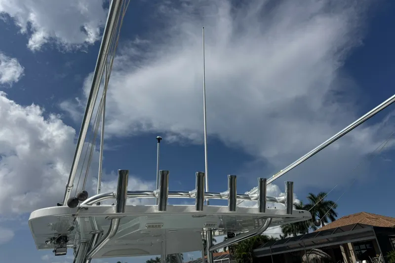 Slide: The Image of 2013 Invincible 36 Open Fisherman boat with rod holders against a cloudy sky. - 11