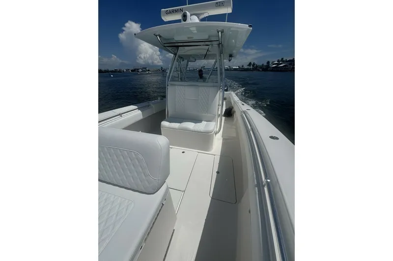 Slide: The Image of 2013 Invincible 36 Open Fisherman boat on water, featuring sleek design and spacious deck. - 6