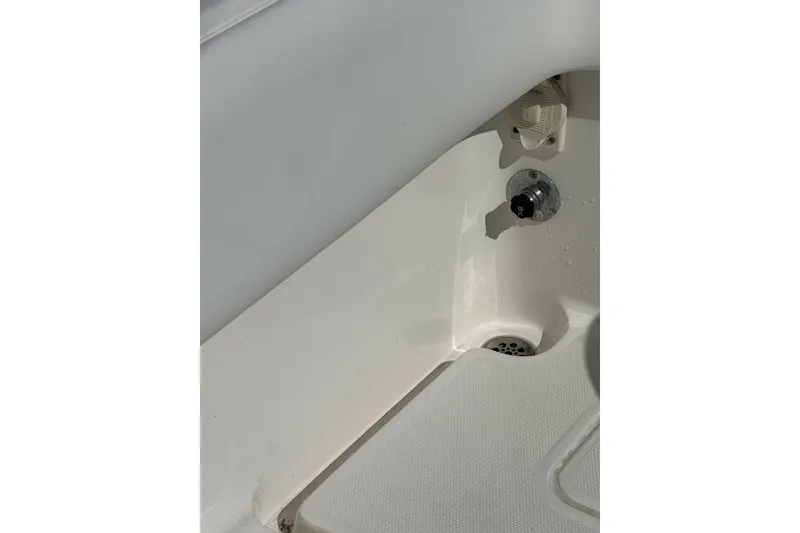 Slide: The Image of Interior detail of 2013 Invincible 36 Open Fisherman boat, featuring a drain and control knob. - 9