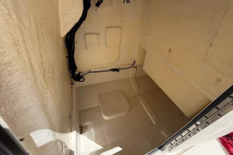 Slide: The Image of 2024 Bayliner Trophy T22CC storage compartment interior with wiring visible. - 51