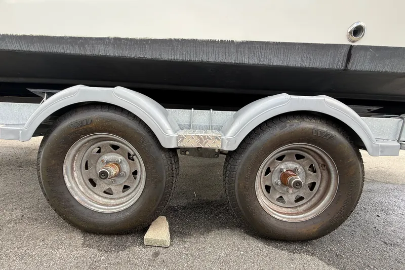 Slide: The Image of Trailer wheels of a 2024 Bayliner Trophy T22CC boat on pavement. - 71