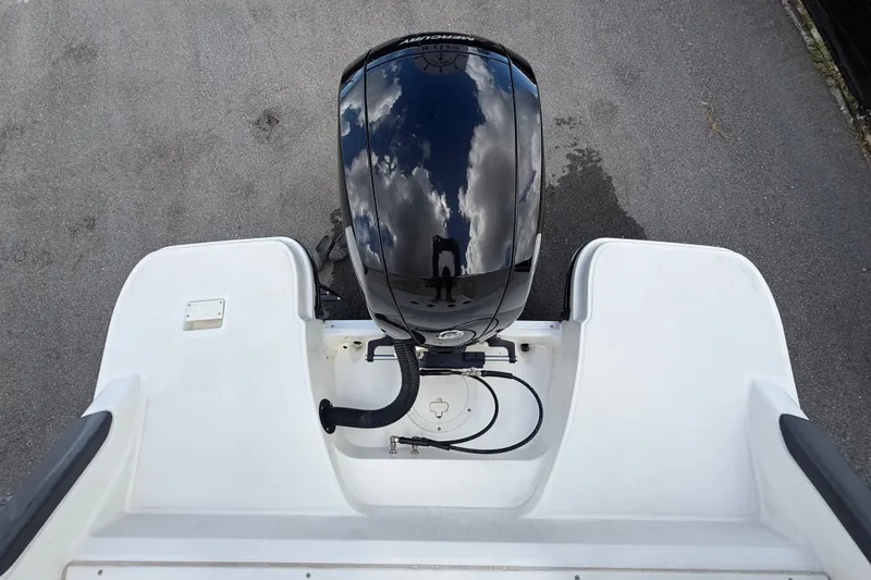 Slide: The Image of 2024 Bayliner Trophy T22CC boat engine with reflective surface and sky reflection. - 65