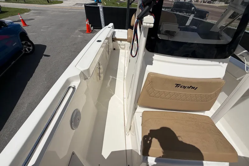 Slide: The Image of La imagen muestra la cubierta de un Bayliner Trophy T22CC 2024 con asientos beige y consola de mando. - 48