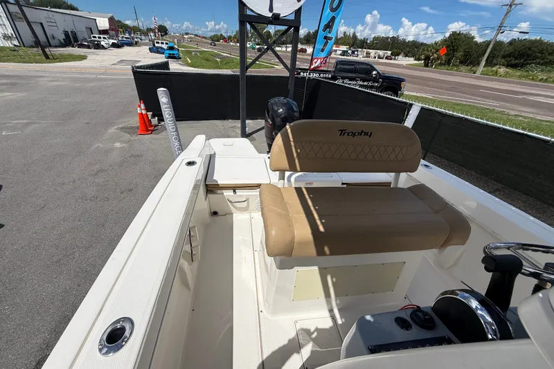 Slide: The Image of 2024 Bayliner Trophy T22CC boat interior with tan seating and control panel. - 54