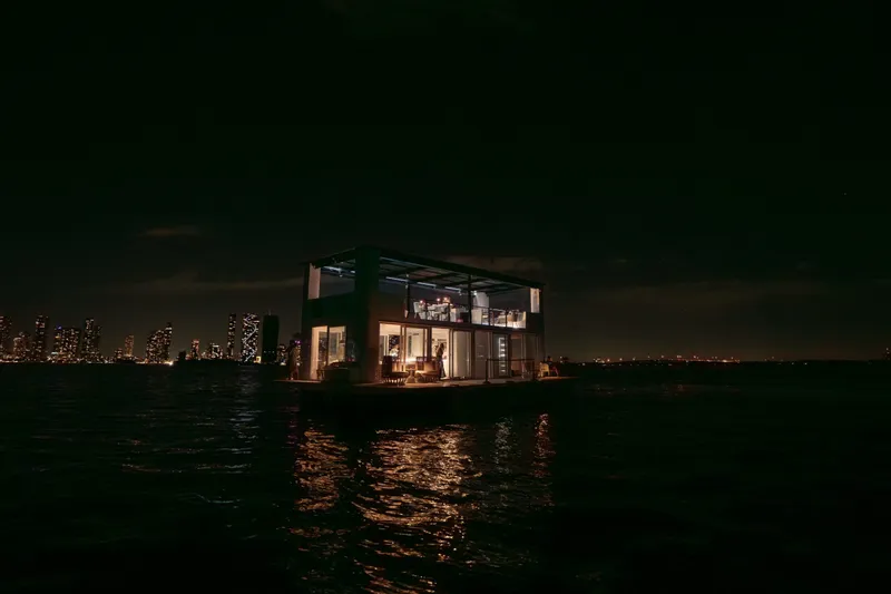 Slide: The Image of Floating Arkhaus Villa 50 at night, city skyline in background, 2025 model. - 12