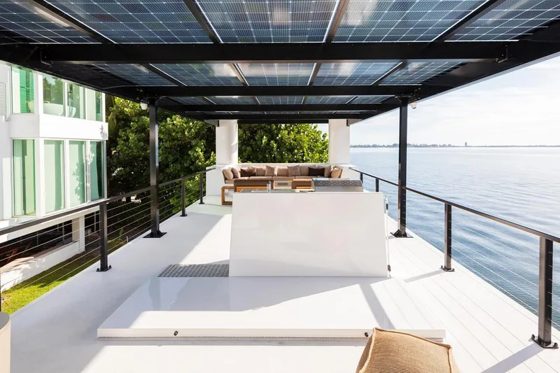 Slide: The Image of Modern Arkhaus Villa 50 rooftop terrace with solar panels, overlooking serene waterfront, 2025 model. - 10