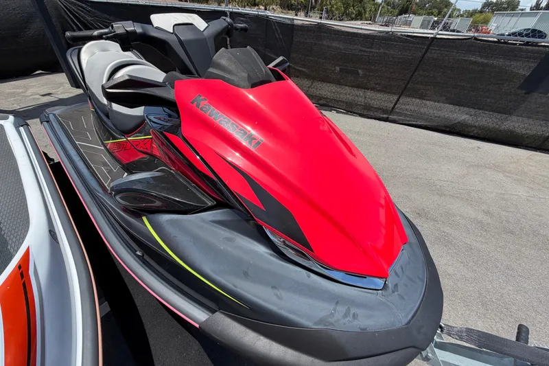 Slide: The Image of 2024 Kawasaki Jetski STX 160LX in vibrant red, parked outdoors. - 25