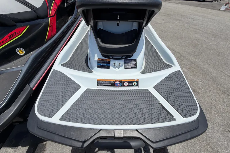 Slide: The Image of 2024 Kawasaki Jetski STX 160LX rear deck with textured footrests and safety labels. - 28