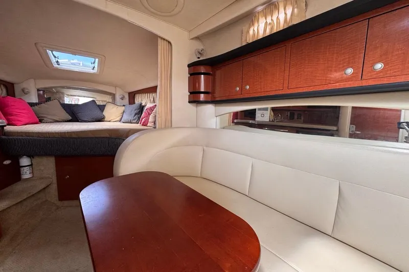 Slide: The Image of Interior of 2005 Sea Ray 300 Sundancer with cozy seating and wooden cabinetry. - 83