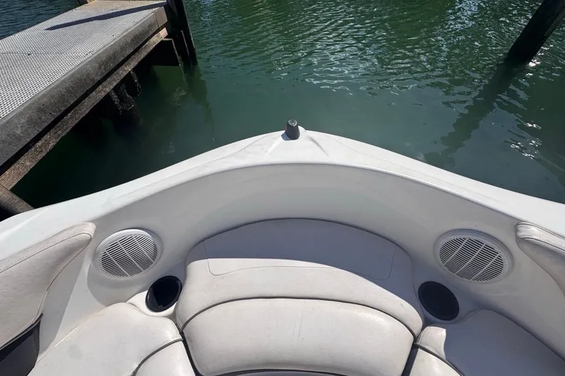 Slide: The Image of 2012 Yamaha Boats SX190 bow seating area with speakers and cup holders near dock. - 27