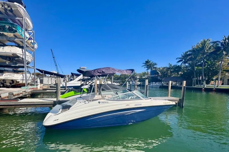 The Image of 2012 Yamaha SX190 boat docked in a sunny marina with palm trees. - 0