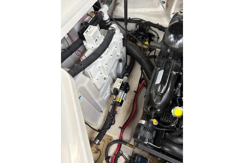 Slide: The Image of Engine compartment of a 2013 Sea Ray 240 Sundancer, showcasing mechanical components and wiring. - 21