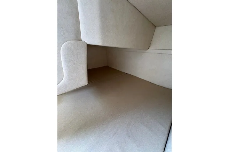 Slide: The Image of Interior cabin of 2013 Sea Ray 240 Sundancer, featuring beige upholstery and compact design. - 13