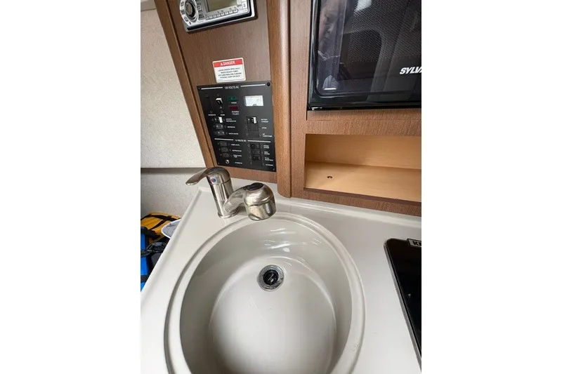 Slide: The Image of Interior of 2013 Sea Ray 240 Sundancer with sink, control panel, and microwave. - 17