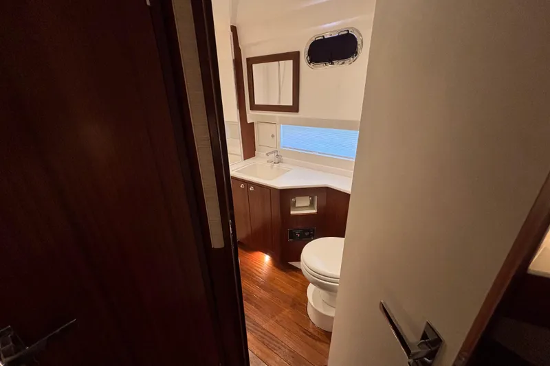 Slide: The Image of 2024 Pursuit OS 445 Offshore yacht bathroom with wooden cabinetry and modern fixtures. - 105