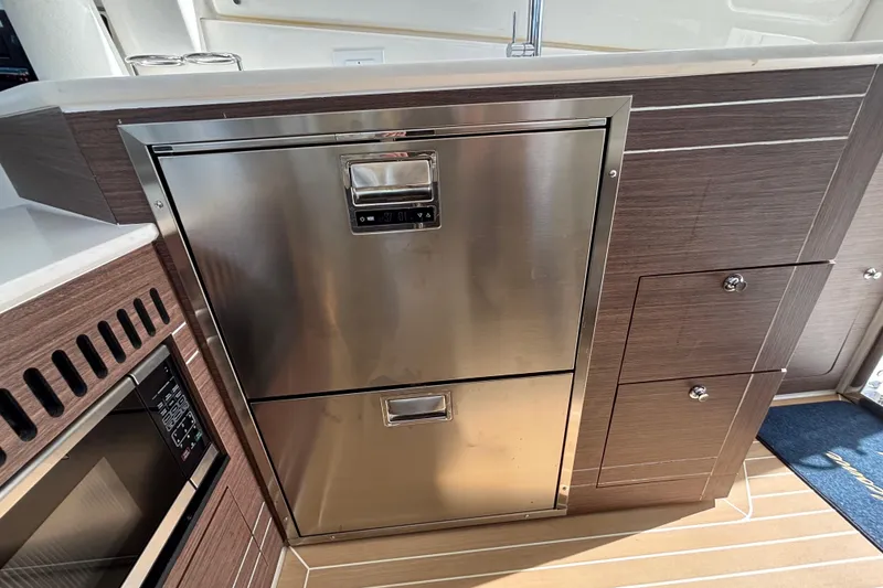 Slide: The Image of 2024 Pursuit OS 445 Offshore yacht kitchen with stainless steel appliances and wood cabinetry. - 67