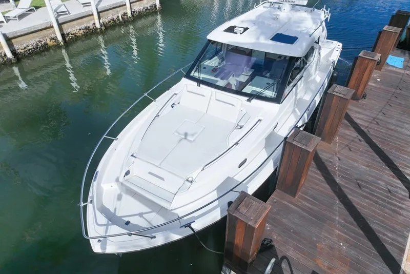 Slide: The Image of 2024 Pursuit OS 445 Offshore boat docked in marina, aerial view. - 11