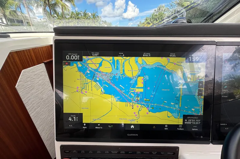 Slide: The Image of 2024 Pursuit OS 445 Offshore boat with Garmin navigation display showing nautical map. - 76