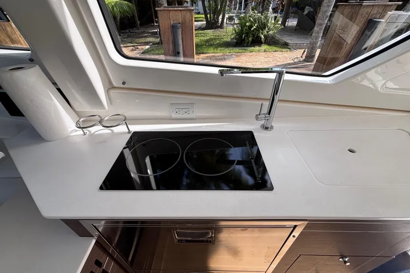 Slide: The Image of 2024 Pursuit OS 445 Offshore yacht kitchen with sleek stovetop and modern faucet. - 68