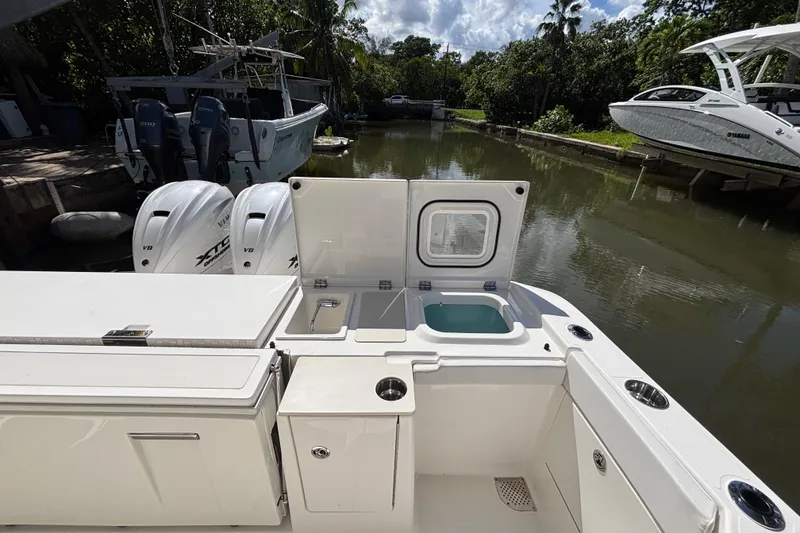 Slide: The Image of 2024 Pursuit OS 445 Offshore boat with open deck and dual outboard engines. - 47