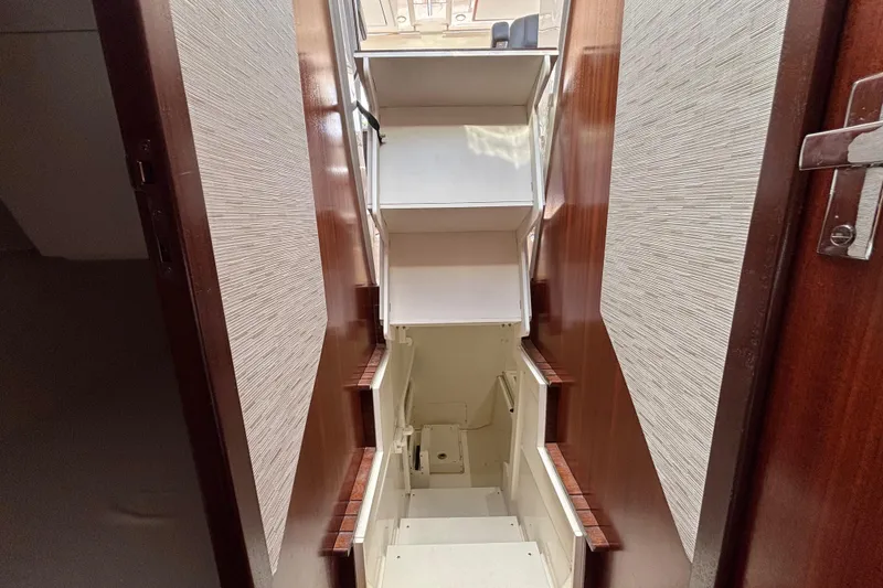 Slide: The Image of 2024 Pursuit OS 445 Offshore interior staircase with wooden accents and modern design. - 116