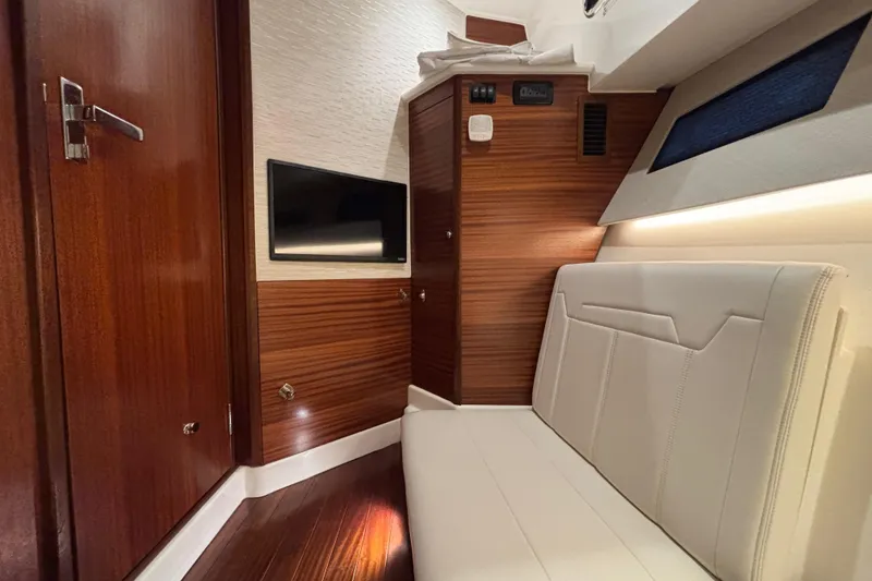 Slide: The Image of 2024 Pursuit OS 445 Offshore cabin interior with wood paneling and modern seating. - 114