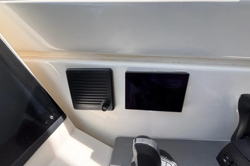 Slide: The Image of 2024 Pursuit OS 445 Offshore boat dashboard with Garmin speaker and control panel. - 99