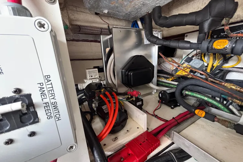 Slide: The Image of 2024 Pursuit OS 445 Offshore engine compartment with battery switch panel and wiring. - 130