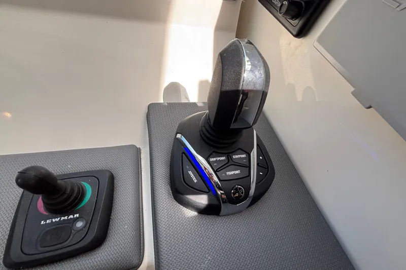 Slide: The Image of 2024 Pursuit OS 445 Offshore boat controls with joystick and throttle levers. - 83