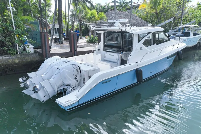 Slide: The Image of 2024 Pursuit OS 445 Offshore boat docked, featuring Yamaha engines and sleek design. - 9