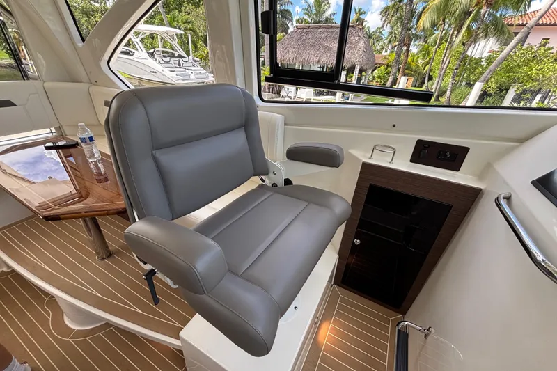 Slide: The Image of 2024 Pursuit OS 445 Offshore interior with gray captain's chair and wooden accents. - 91