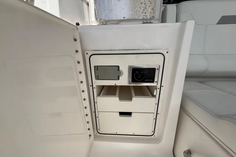 Slide: The Image of 2024 Pursuit OS 445 Offshore interior storage compartment with Kenyon control panel. - 55