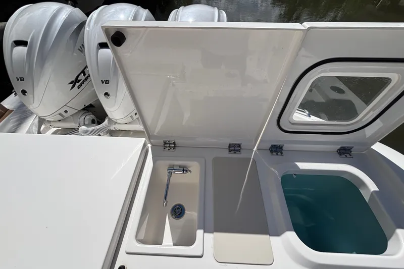 Slide: The Image of 2024 Pursuit OS 445 Offshore boat with open storage compartments and dual V8 engines. - 49