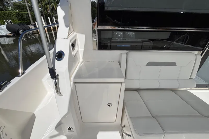 Slide: The Image of 2024 Pursuit OS 445 Offshore boat interior with white seating and storage area. - 52