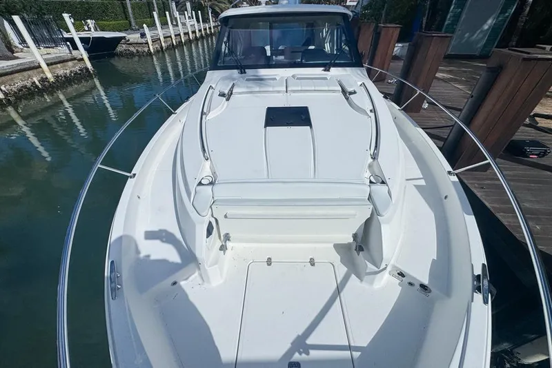 Slide: The Image of 2024 Pursuit OS 445 Offshore boat docked, showcasing spacious deck and sleek design. - 21