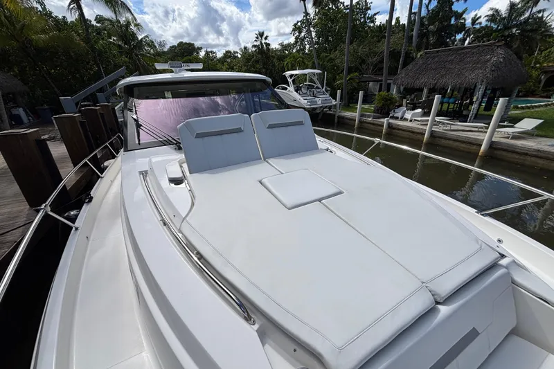 Slide: The Image of 2024 Pursuit OS 445 Offshore yacht with sun deck, docked near tropical surroundings. - 29