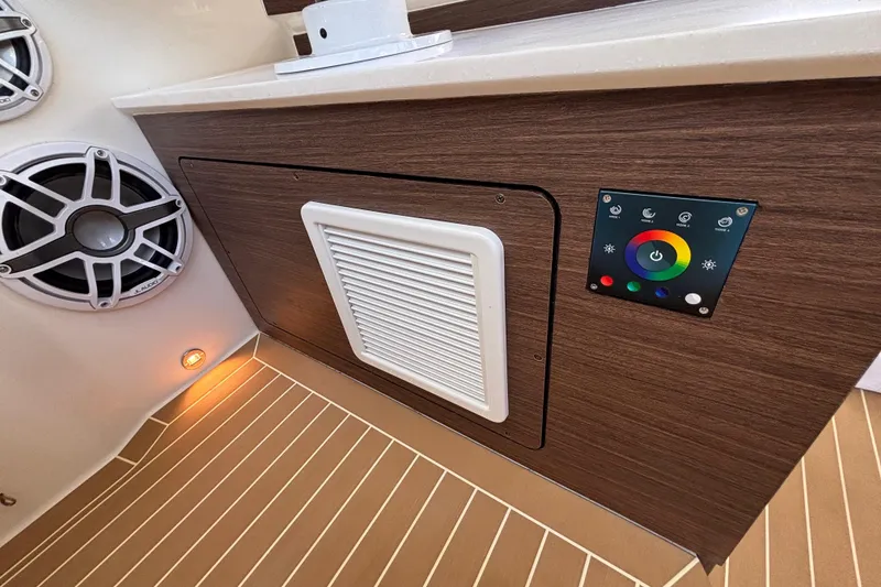 Slide: The Image of 2024 Pursuit OS 445 Offshore interior with speaker, control panel, and wood finish. - 100