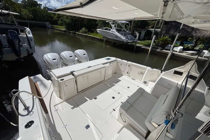 Slide: The Image of 2024 Pursuit OS 445 Offshore boat with spacious deck and triple outboard engines. - 42