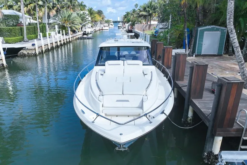Slide: The Image of 2024 Pursuit OS 445 Offshore yacht docked in a scenic canal setting. - 14