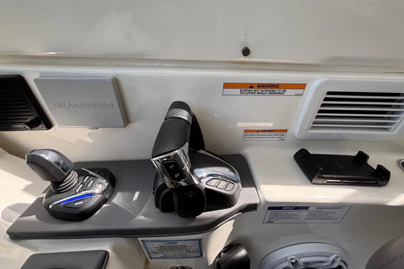 Slide: The Image of 2024 Pursuit OS 445 Offshore control panel with joystick and throttle levers. - 84