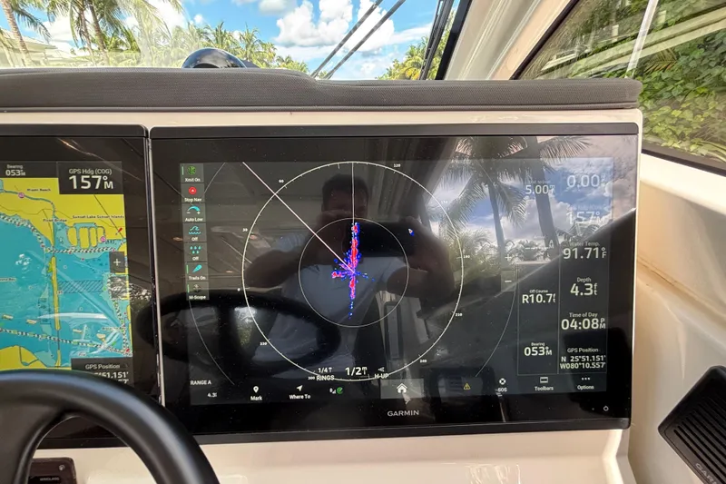 Slide: The Image of 2024 Pursuit OS 445 Offshore boat dashboard with Garmin navigation display. - 77