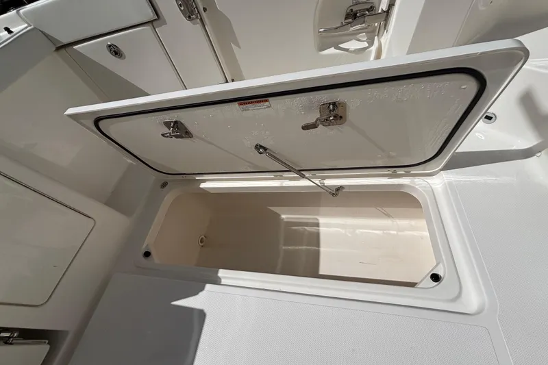 Slide: The Image of 2024 Pursuit OS 445 Offshore storage compartment with open hatch, showcasing interior space. - 56