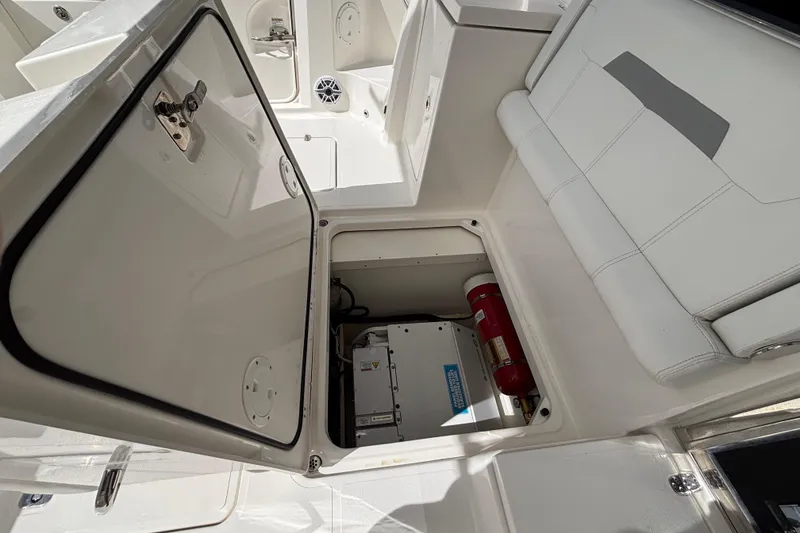 Slide: The Image of 2024 Pursuit OS 445 Offshore boat storage compartment with fire extinguisher and equipment. - 122