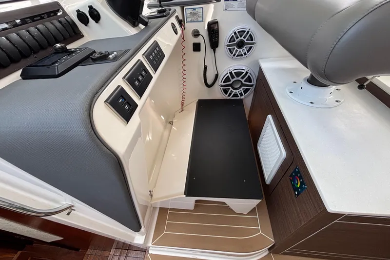 Slide: The Image of 2024 Pursuit OS 445 Offshore boat interior with control panel and seating area. - 87